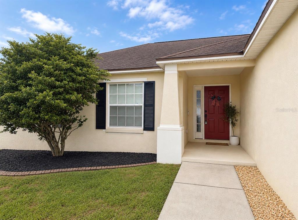 An open-concept living room and kitchen with white cabinets, a breakfast bar, and vaulted ceilings — 3045 LILLIAN PASS, LAKELAND, FL