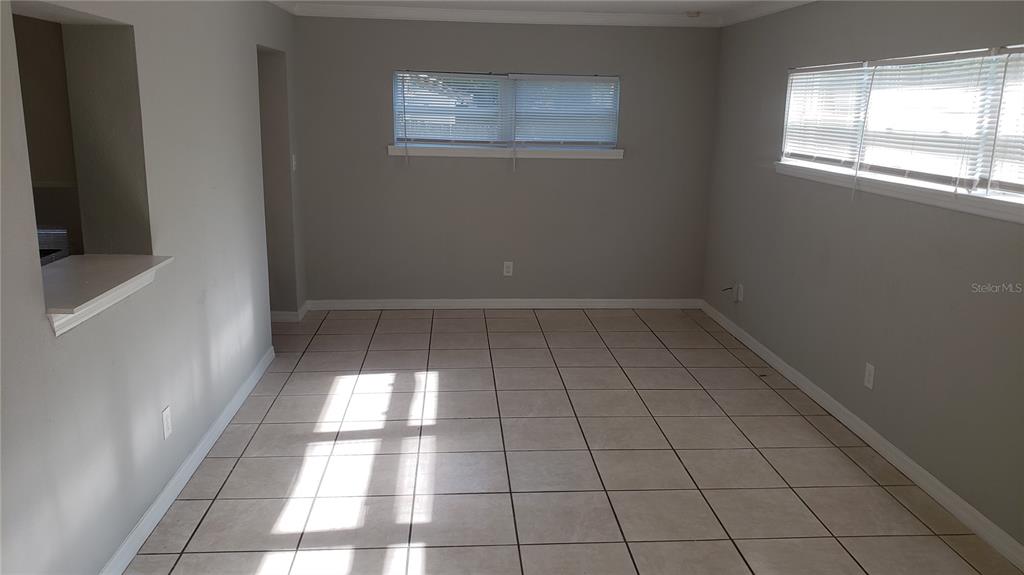 An empty room with light-colored tile flooring, gray walls, and two windows with blinds — 887 EASTBROOK BOULEVARD, WINTER PARK, FL