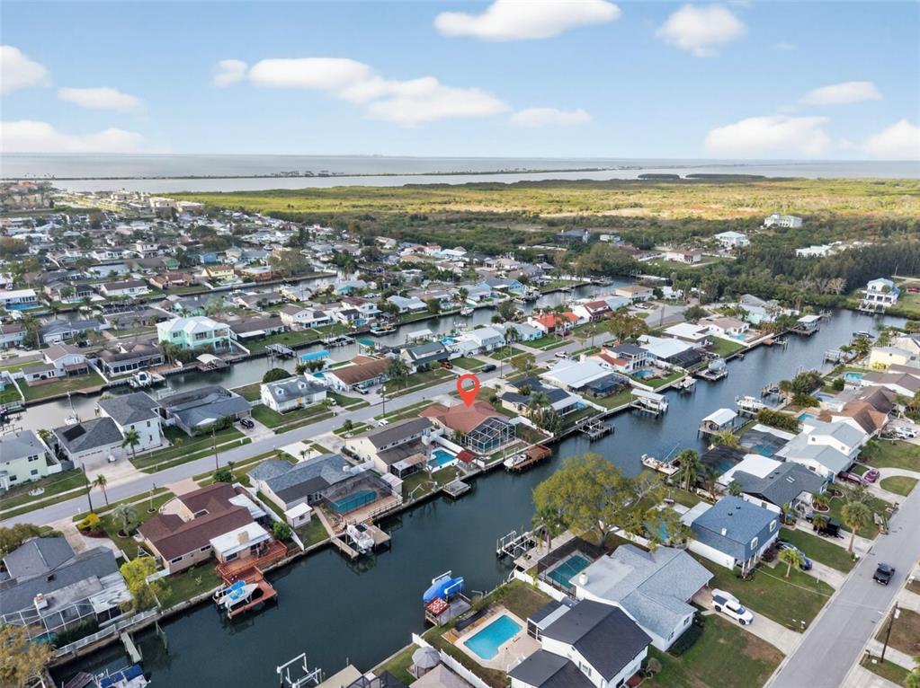 A screened-in swimming pool overlooks a canal with a private boat dock and deck — 8711 BAY CREST LANE, TAMPA, FL