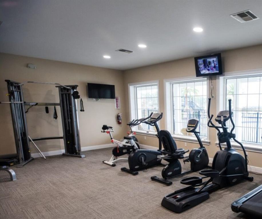 A fitness room features a cable machine, stationary bikes, an elliptical, and wall-mounted televisions — 0 HIGHWAY 630 E UNIT 211, LAKE WALES, FL