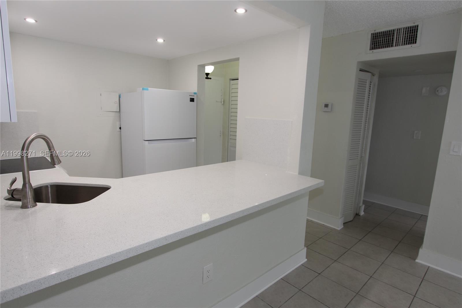 A kitchen features a white countertop, a stainless steel sink, and a white refrigerator — 4550 NW 9th St # 811E, Miami FL 33126, MIAMI, FL