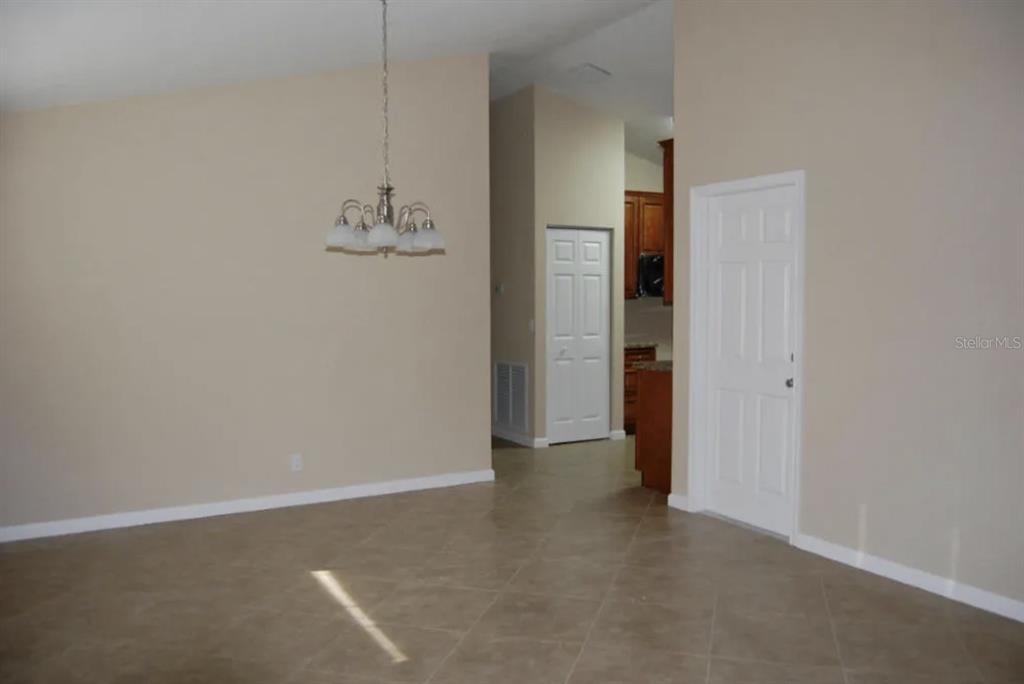 A dining area with tile floors, a chandelier, and a doorway leading to a kitchen — 926 SW 11TH TERRACE, DELRAY BEACH, FL