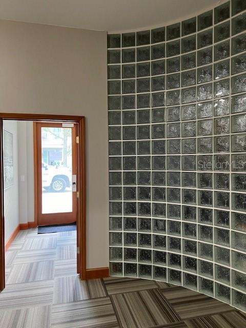 A curved glass block wall stands next to a doorway leading to an outdoor area — 4965 SW 91ST TERRACE, GAINESVILLE, FL