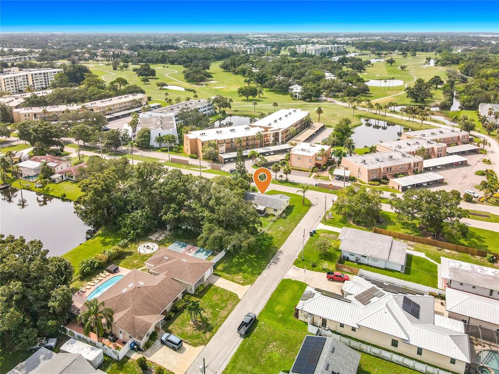 An aerial view shows a residential neighborhood with a golf course and apartment complexes nearby — 105 JUDY LEE DRIVE, LARGO, FL