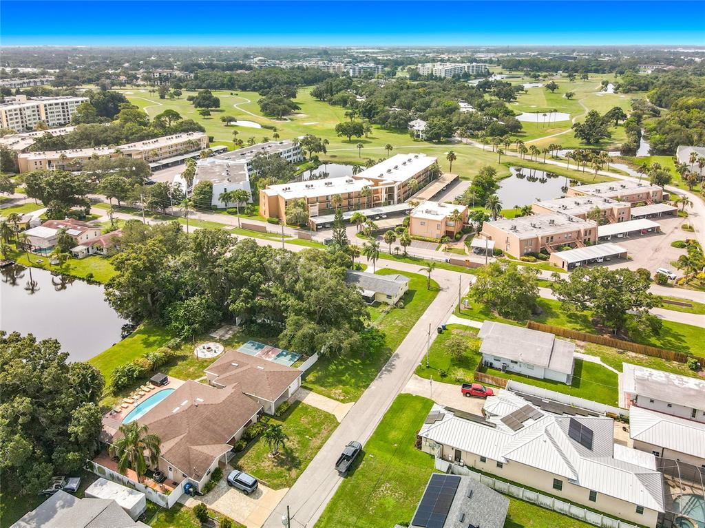 An aerial view shows a residential neighborhood with houses, apartment complexes, and a golf course — 105 JUDY LEE DRIVE, LARGO, FL