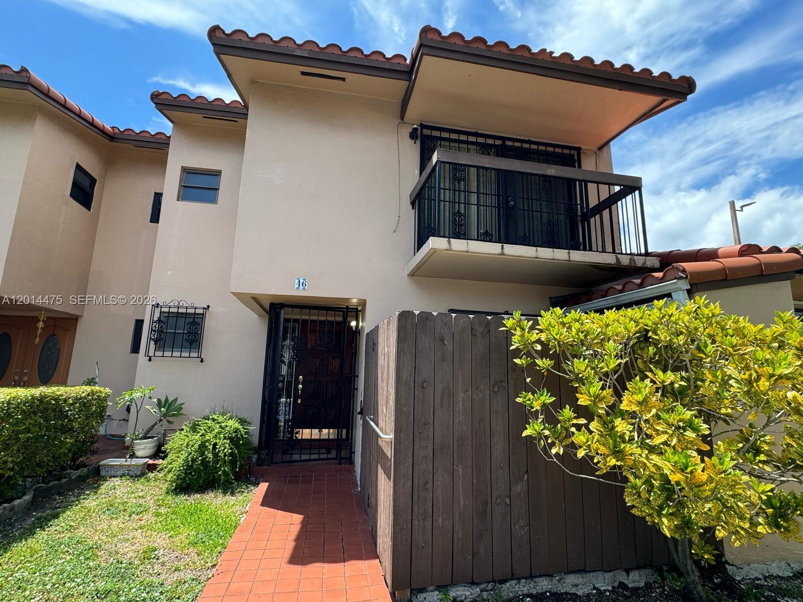 A two-story stucco townhouse features a tiled roof, a balcony, and a gated entryway — 3817 SW 82nd Ave # 46, Miami FL 33155, MIAMI, FL