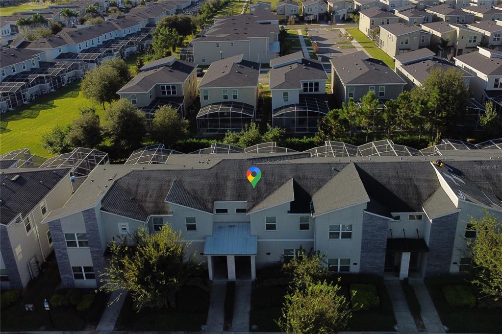 An aerial view shows a multi-unit townhouse building with gray siding and shingled roofs — 436 OCEAN COURSE AVENUE, DAVENPORT, FL