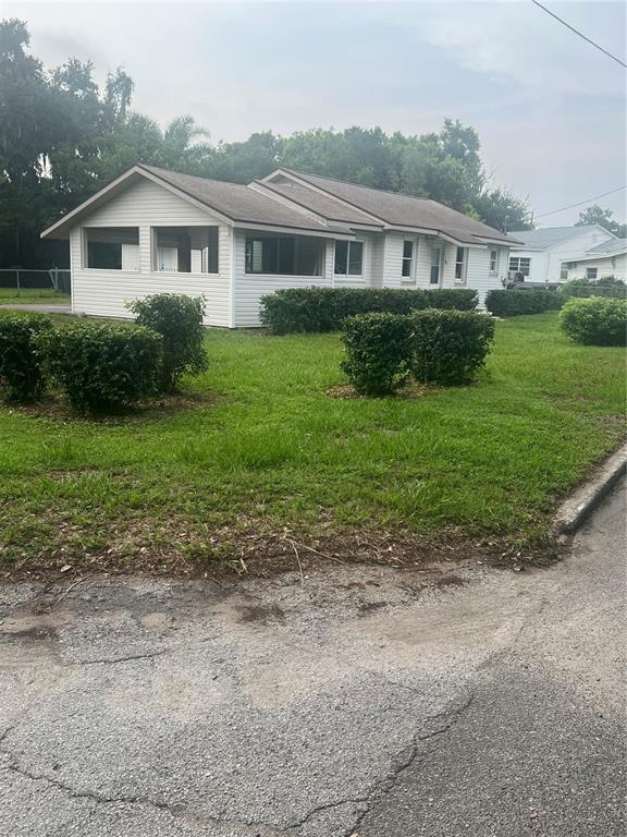 A single-story house with light siding and a screened-in porch sits on a grassy lot — 860 LUSK PLACE, BARTOW, FL