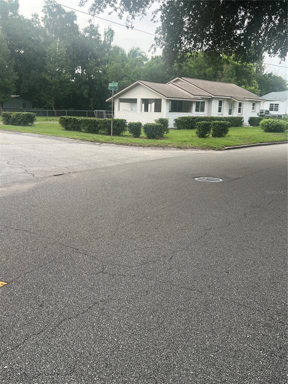 A single-story house with a screened porch sits on a corner lot near a street — 860 LUSK PLACE, BARTOW, FL