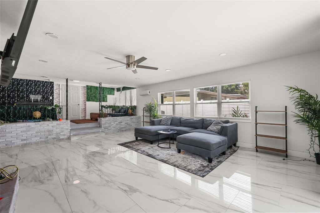 A living room features white marble-look tile floors, a gray sectional sofa, and a raised area — 2909 HARGILL DRIVE, ORLANDO, FL
