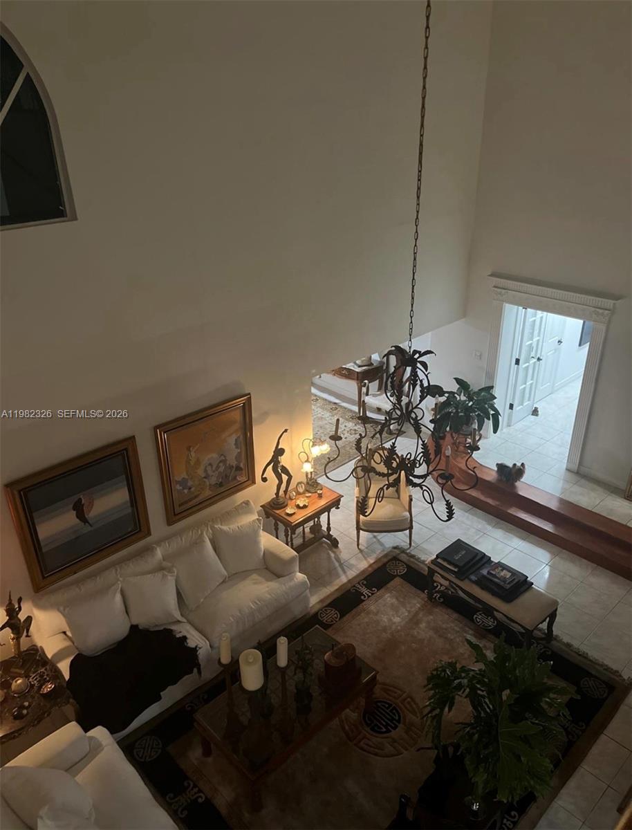 A high-angle view of a living room with a chandelier, white sofa, and area rug — 2190 SW 22 terrace, Miami FL 33145, MIAMI, FL