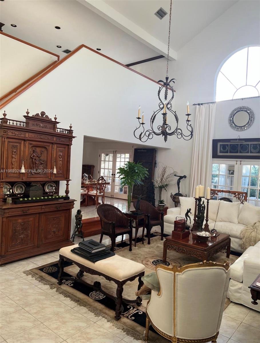 A high-ceilinged living room features a large wooden hutch, white sofa, and ornate chandelier — 2190 SW 22 terrace, Miami FL 33145, MIAMI, FL