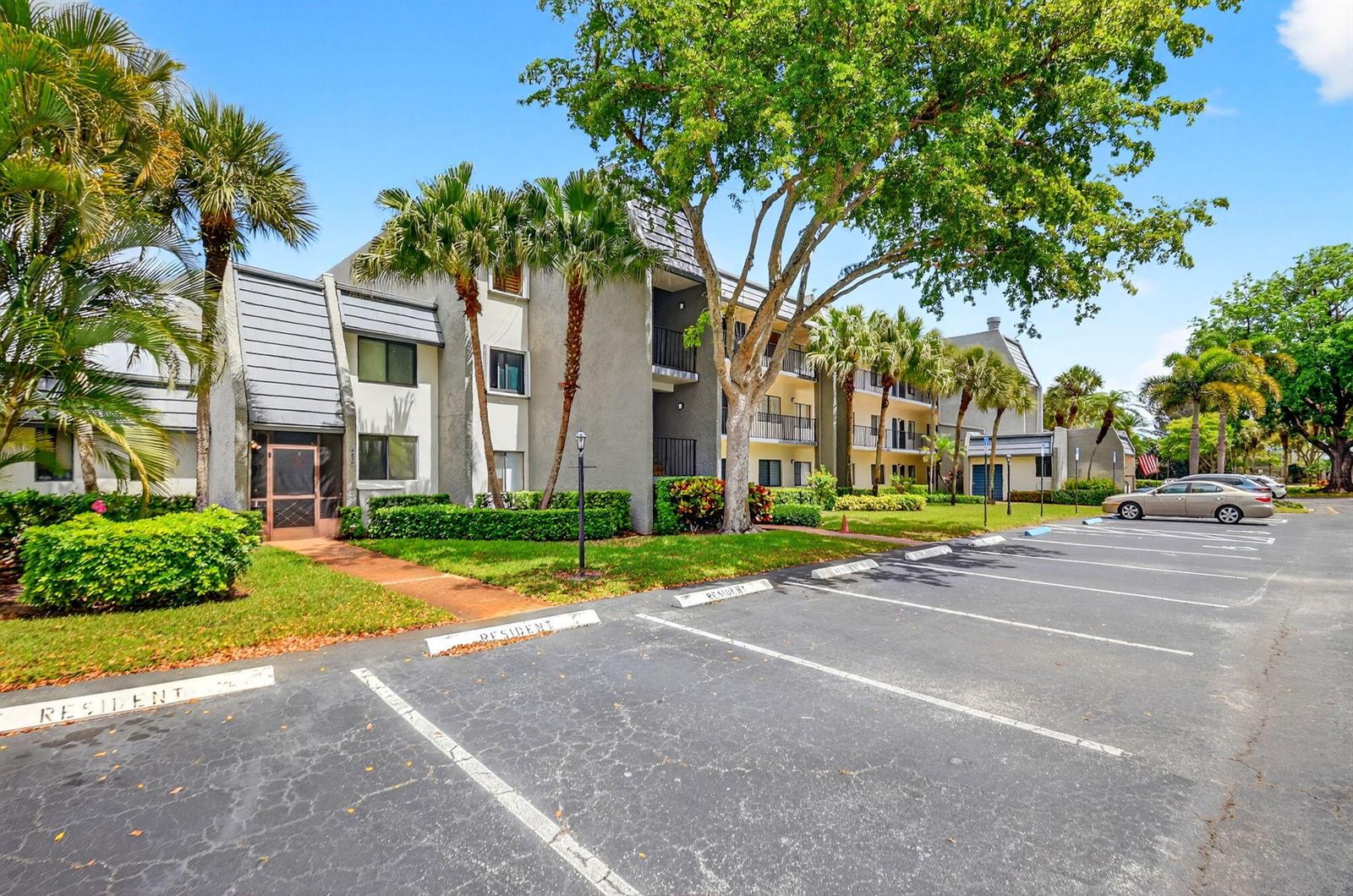 A multi-story apartment building with a parking lot in the foreground and palm trees — 4832 Esedra Court # 103, FL 33467, FL