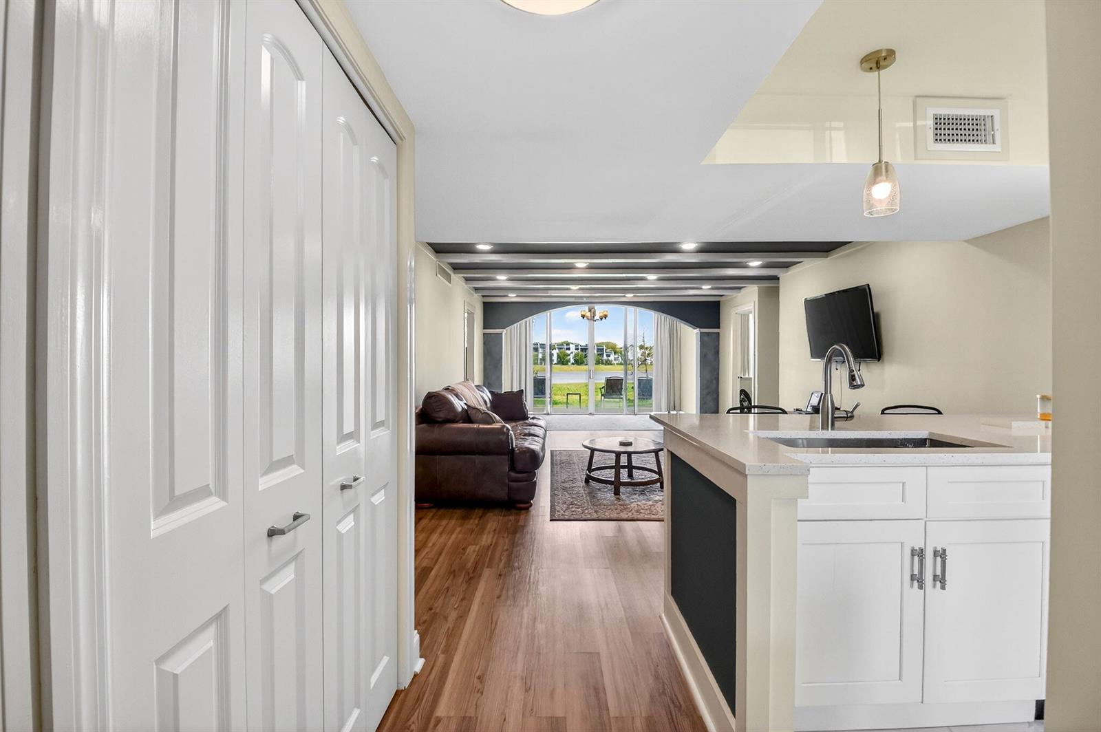 A view from a kitchen area looking toward a living room with a water view — 4832 Esedra Court # 103, FL 33467, FL