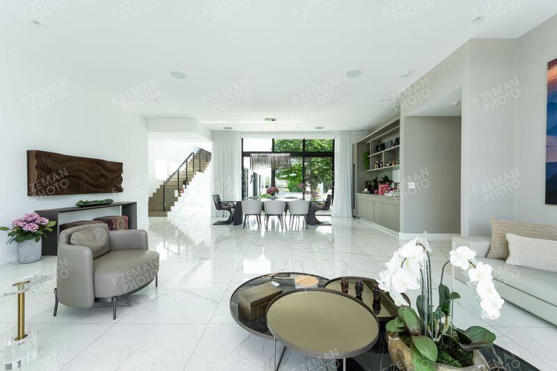 A modern, open-concept living and dining area features white marble flooring and large glass doors — 16550 Sunset Way, Weston FL 33326, WESTON, FL