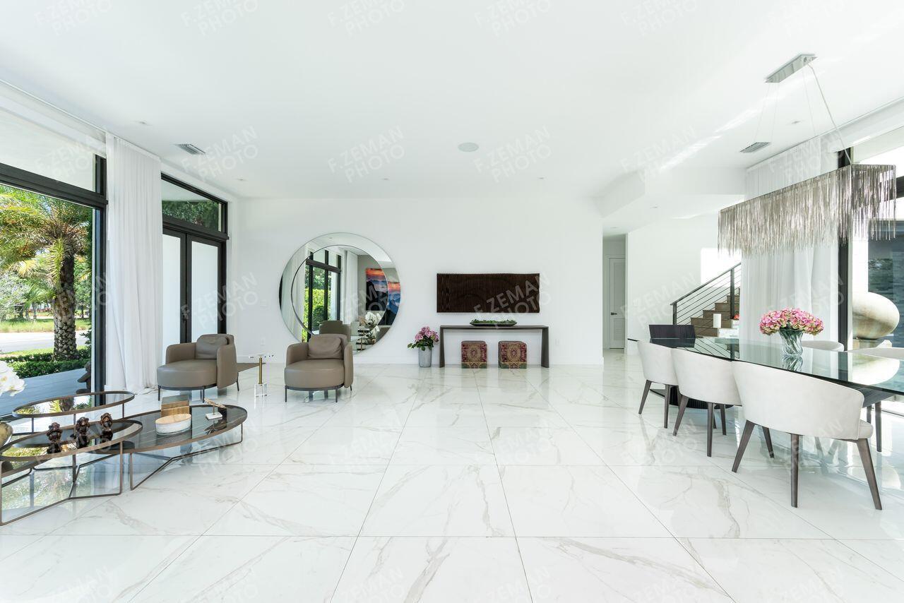 A bright, open-concept living and dining area features white marble floors and floor-to-ceiling windows — 16550 Sunset Way, Weston FL 33326, WESTON, FL