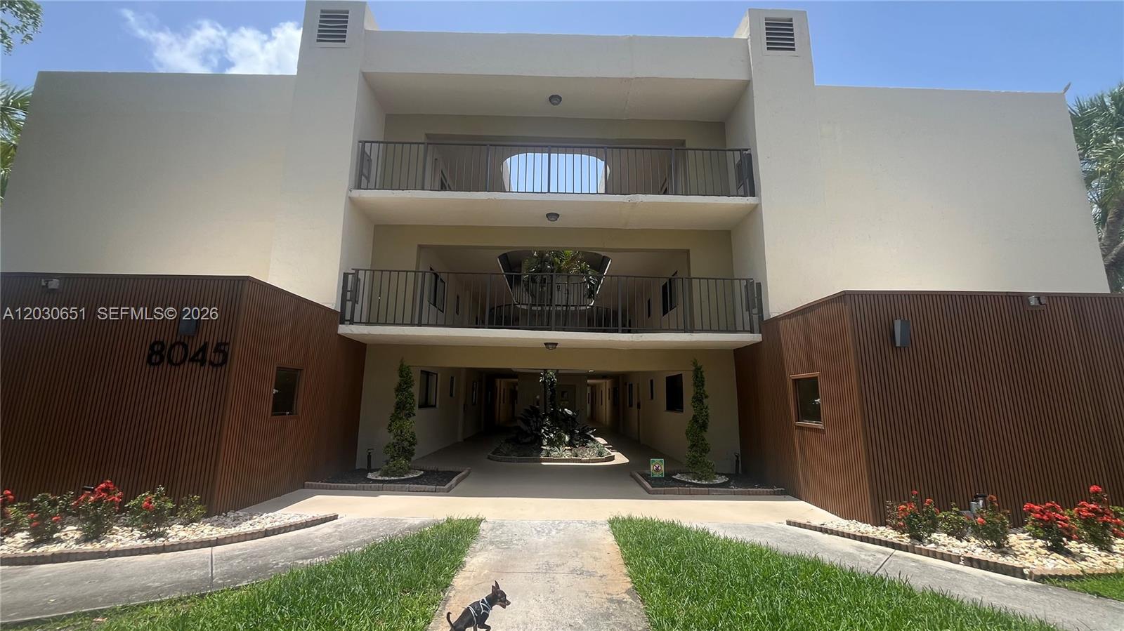 The exterior of a three-story apartment building features brown wood paneling and open balconies — 8045 SW 107th Ave # 217, Miami FL 33173, MIAMI, FL