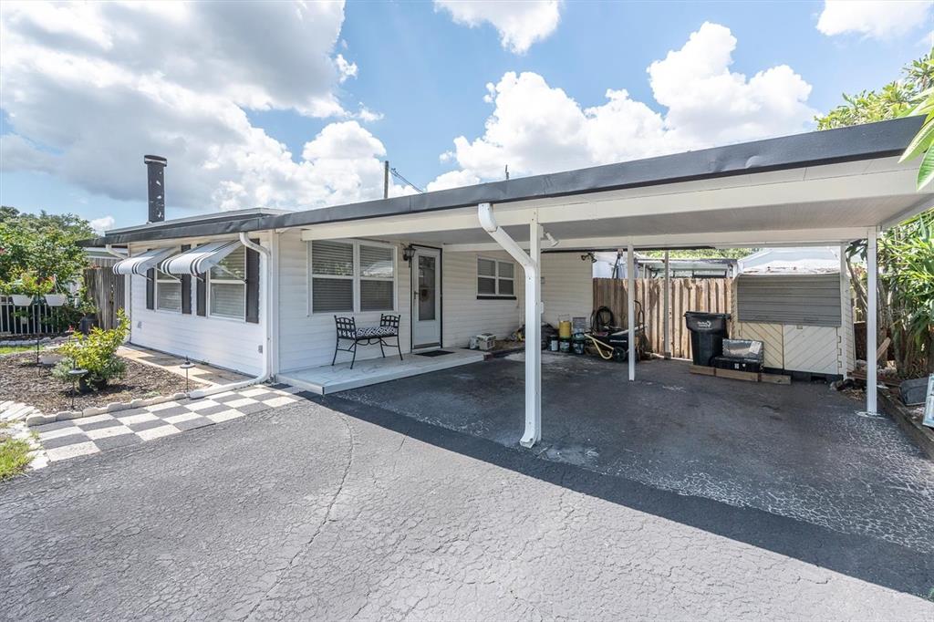 A white mobile home with a carport, asphalt driveway, and a small front patio area — 3227 48TH AVENUE N, ST PETERSBURG, FL