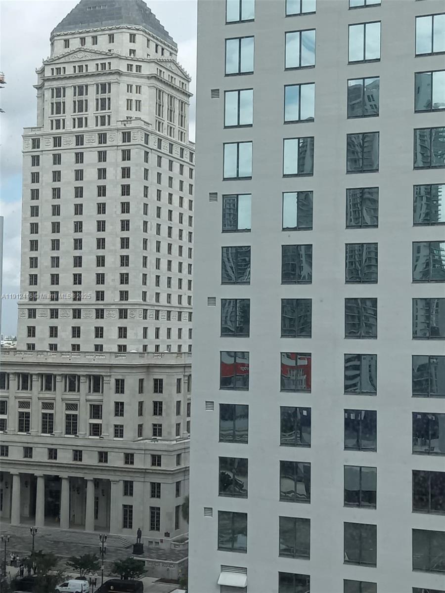 An exterior view shows a historic stone building next to a modern glass-paneled skyscraper — 30 SW 1st St # 601, Miami FL 33130, MIAMI, FL