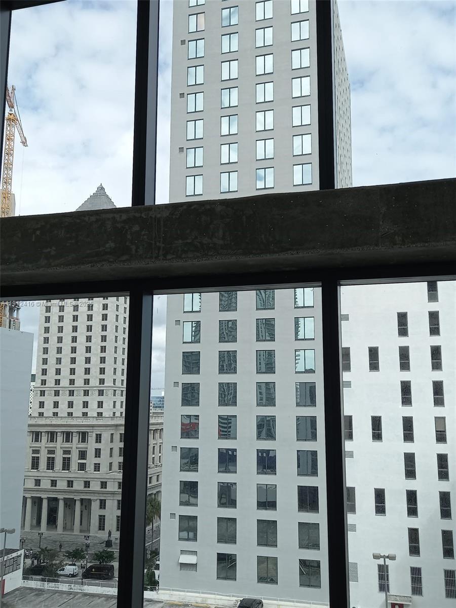 View of multiple high-rise buildings through a large window with a concrete header — 30 SW 1st St # 601, Miami FL 33130, MIAMI, FL