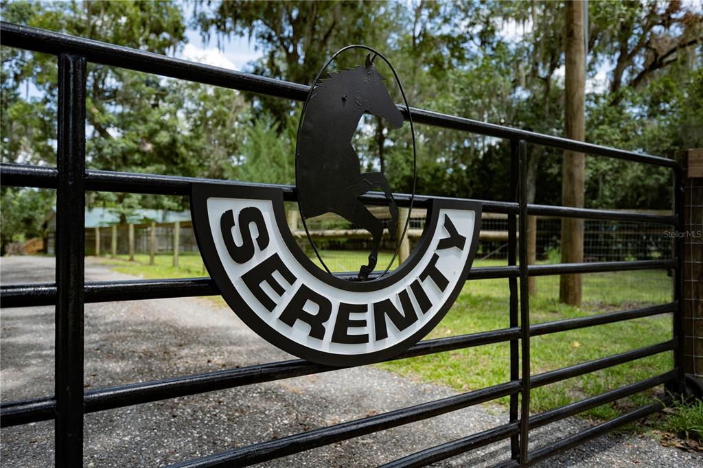 A black metal gate features a horse silhouette and the word Serenity on a sign — 18251 NW 141ST AVENUE, WILLISTON, FL
