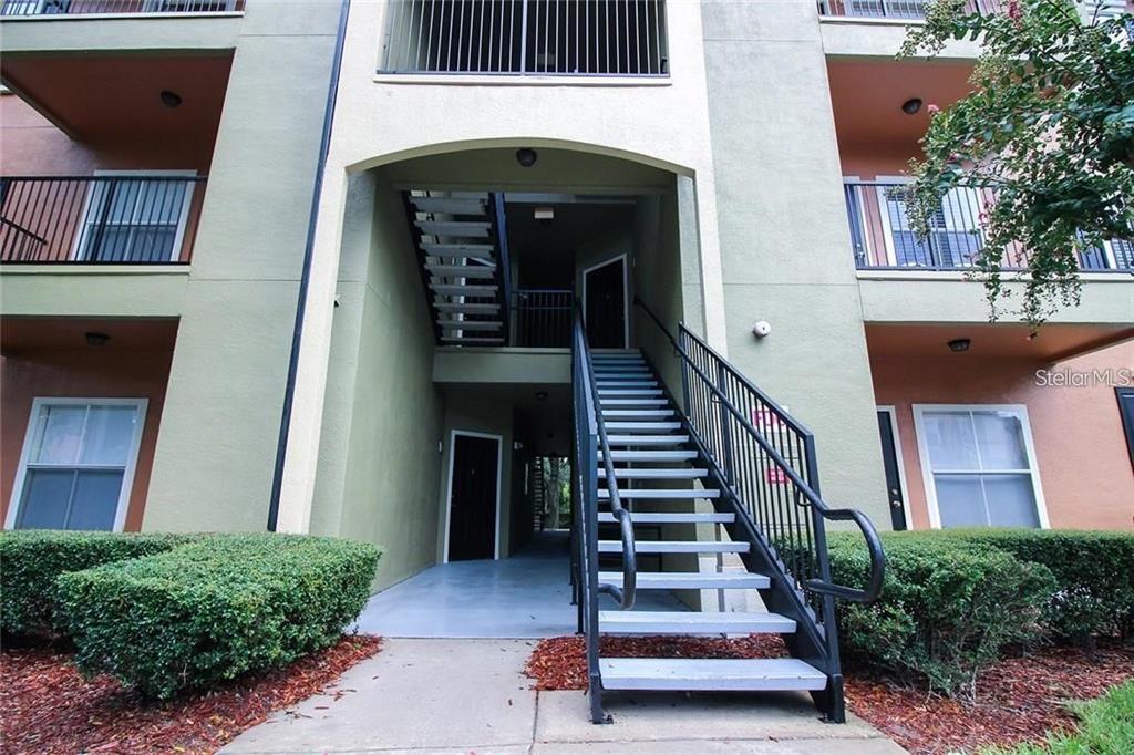 An exterior view of a multi-story apartment building featuring an outdoor staircase and balconies — 6029 WESTGATE DRIVE UNIT 725, ORLANDO, FL