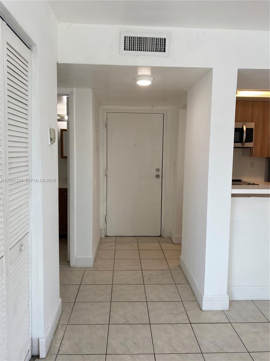 A tiled entryway leads to a white front door with a kitchen visible on the right — 7075 NW 186th St # C308, Hialeah FL 33015, HIALEAH, FL