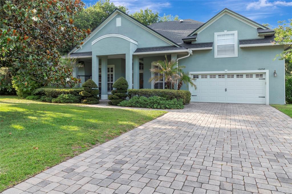 A teal-colored house with a paved driveway, a two-car garage, and a covered front porch — 10838 PRIEBE ROAD, CLERMONT, FL