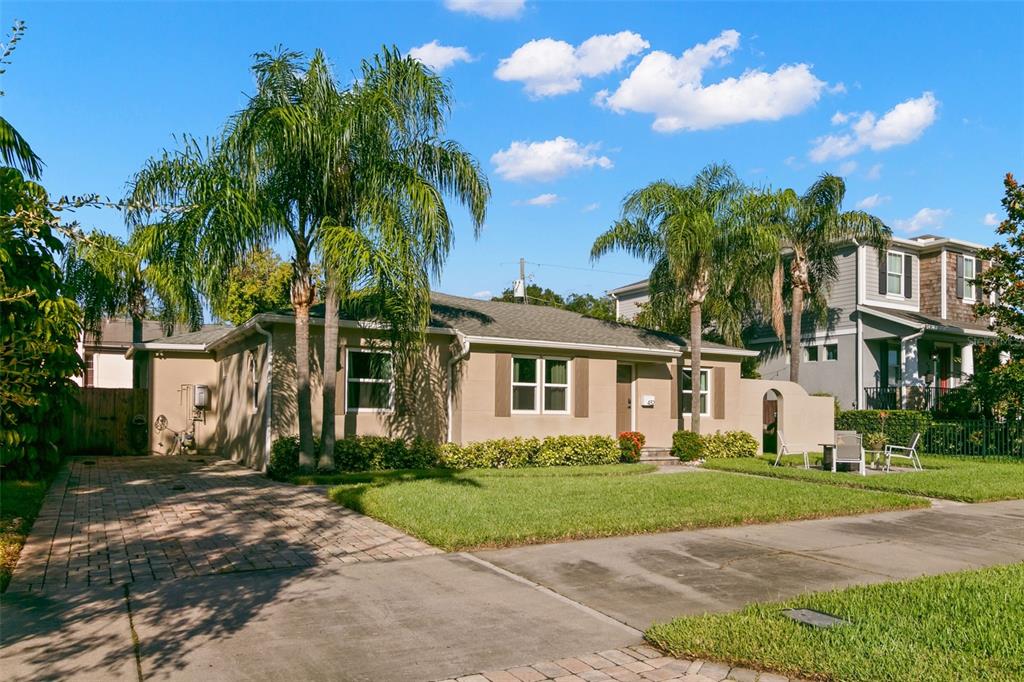 A single-story tan house with a paved driveway, palm trees, and a green lawn — 432 E DAVIS BOULEVARD, TAMPA, FL