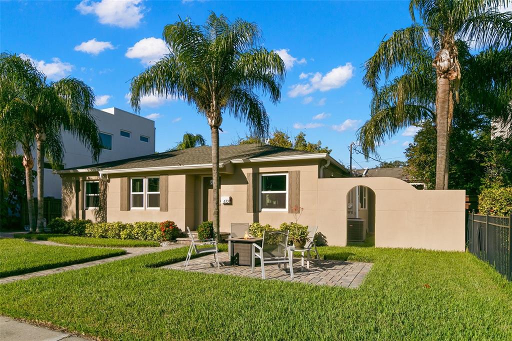 A single-story house with a paved patio, fire pit, and palm trees in the front yard — 432 E DAVIS BOULEVARD, TAMPA, FL