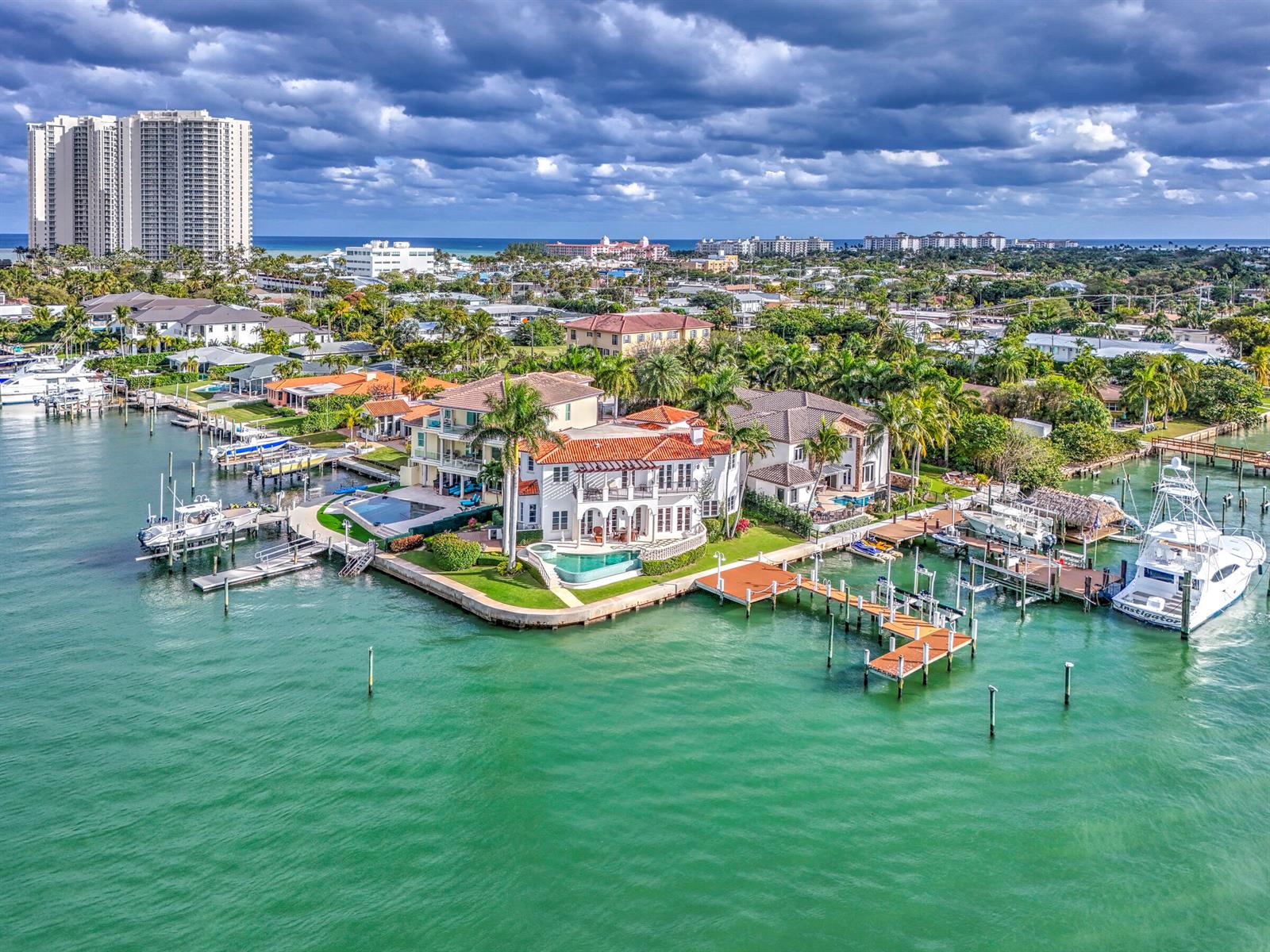 An aerial view of a waterfront mansion with a pool and multiple boat docks — 2775 Lake Drive, Singer Island FL 33404, SINGER ISLAND, FL