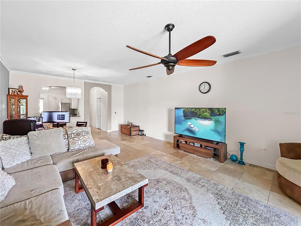 A living room features a sectional sofa, a coffee table, and a ceiling fan — 18141 NASSAU POINT DRIVE, TAMPA, FL