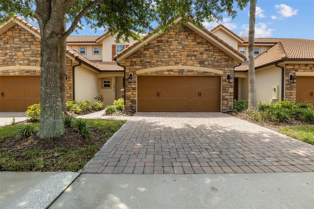 A bright living room features a beige sofa, two armchairs, a coffee table, and tile flooring — 10410 BELFRY CIRCLE, ORLANDO, FL