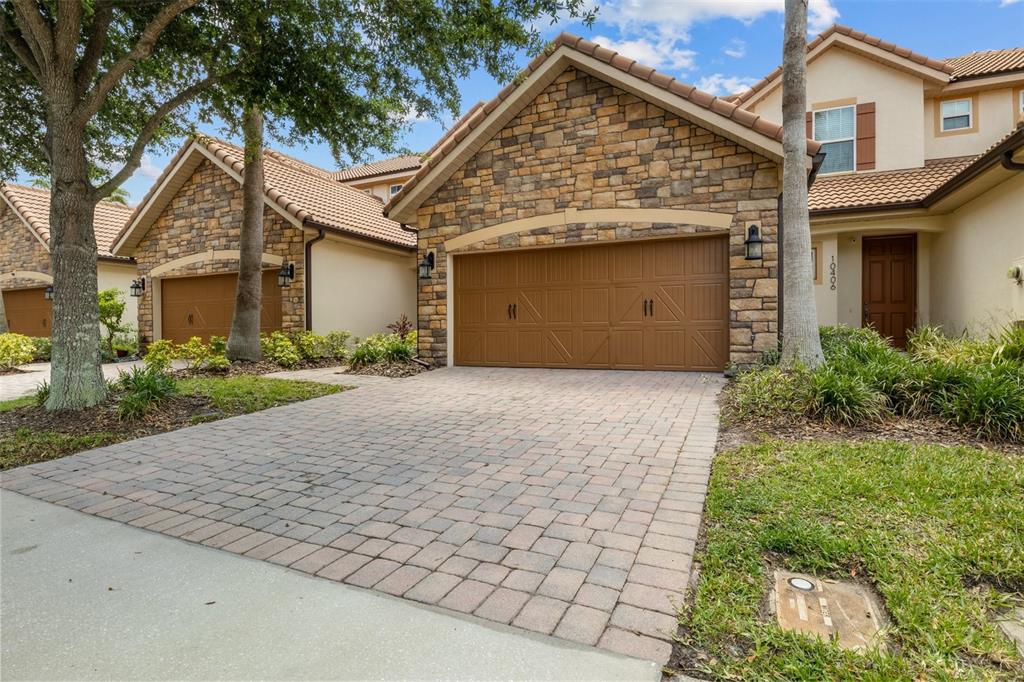 An open-concept living room features a beige sectional, two armchairs, and a kitchen with bar seating — 10410 BELFRY CIRCLE, ORLANDO, FL
