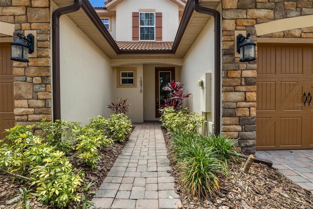 A bedroom features a tufted headboard, a bench, a ceiling fan, and tile flooring — 10410 BELFRY CIRCLE, ORLANDO, FL