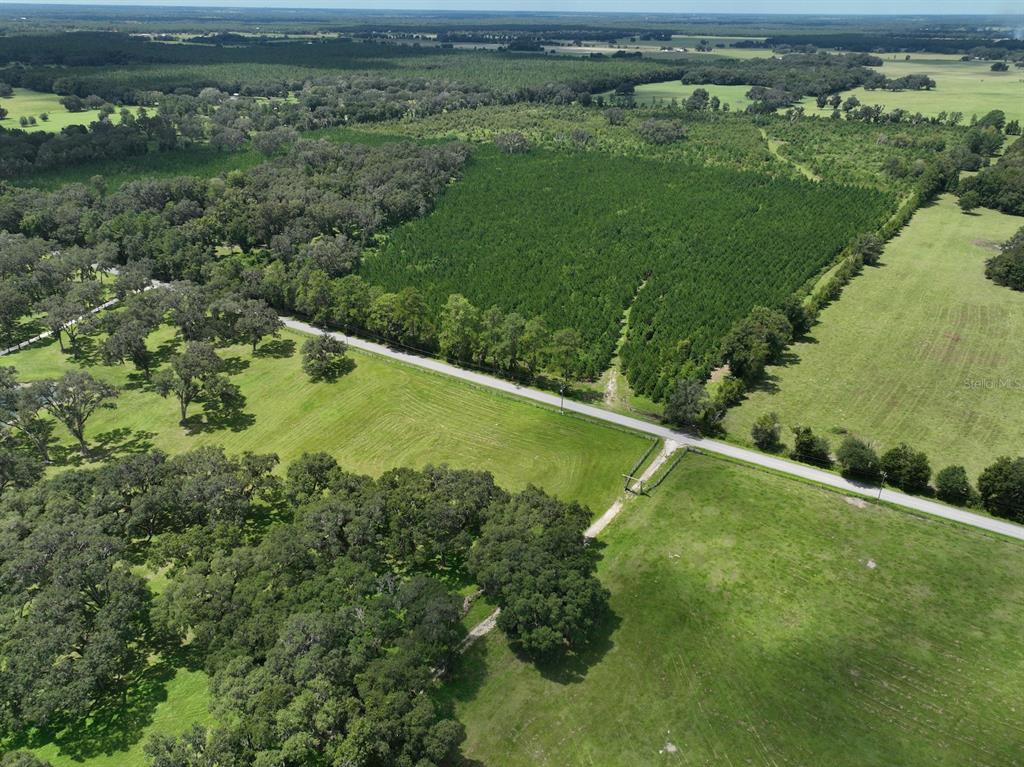 An aerial view shows a rural landscape with a paved road, pastures, and forested areas — TBD (B, C & D Parcels) NW 160TH AVENUE, MORRISTON, FL