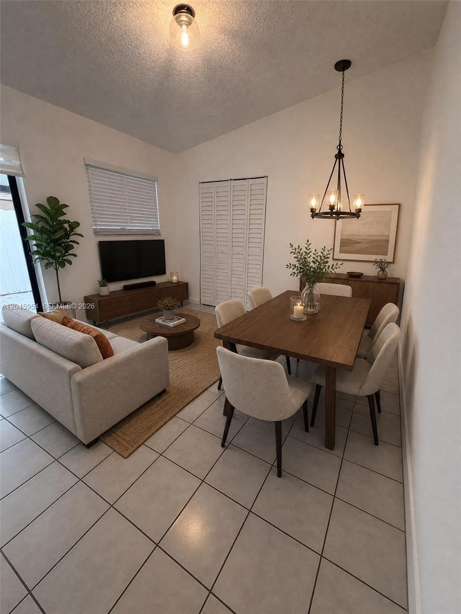 This open-concept living and dining area features tile flooring, neutral furniture, and a wooden table — 10364 NW 128th Ter, Hialeah Gardens FL 33018, HIALEAH GARDENS, FL