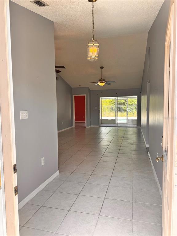 An entryway leads into a living area with gray walls, tile flooring, and vaulted ceilings — 2070 SARAH LOUISE DRIVE, BRANDON, FL