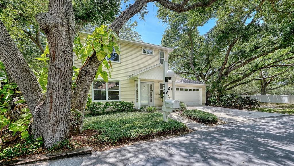 A two-story house with light yellow siding, a white front door, and a garage — 2304 63RD STREET COURT W, BRADENTON, FL