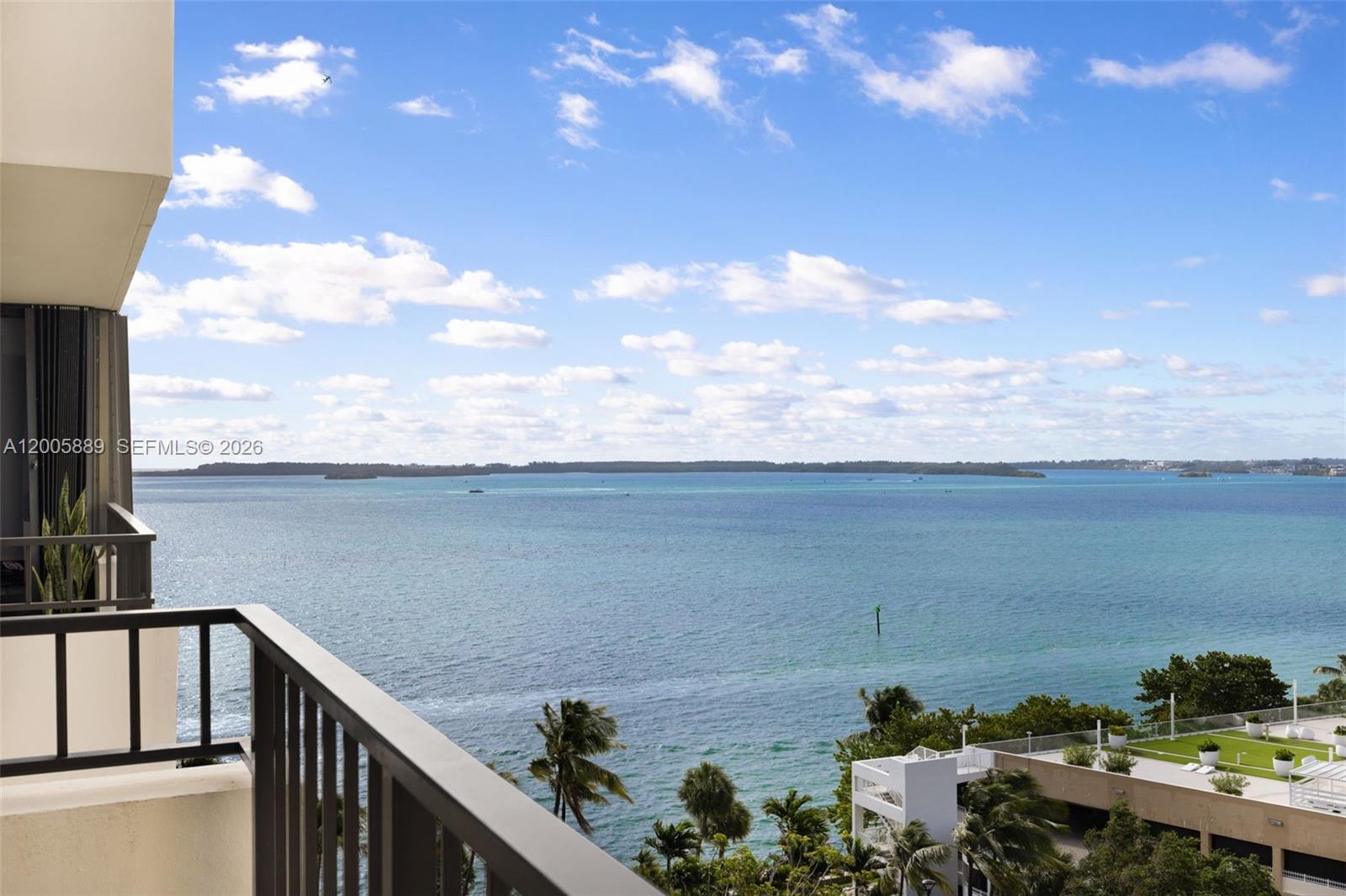 A balcony view overlooking a large body of water under a blue sky — 520 Brickell Key Dr # A1001, Miami FL 33131, MIAMI, FL