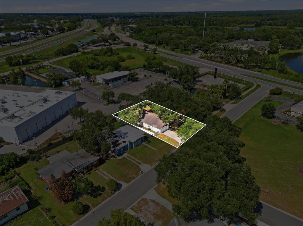 An aerial view shows a single-story house with a white exterior surrounded by mature trees — 217 E EDWARD STREET, LAKELAND, FL