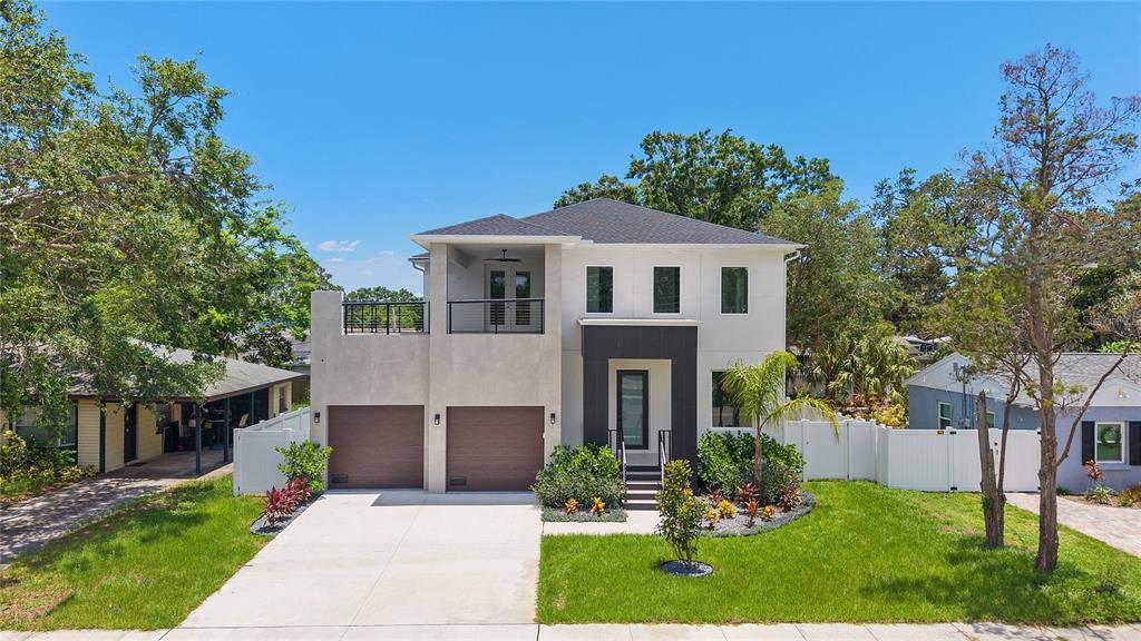 A two-story modern house with a two-car garage, upper balcony, and light-colored stucco exterior — 4604 W EUCLID AVENUE, TAMPA, FL