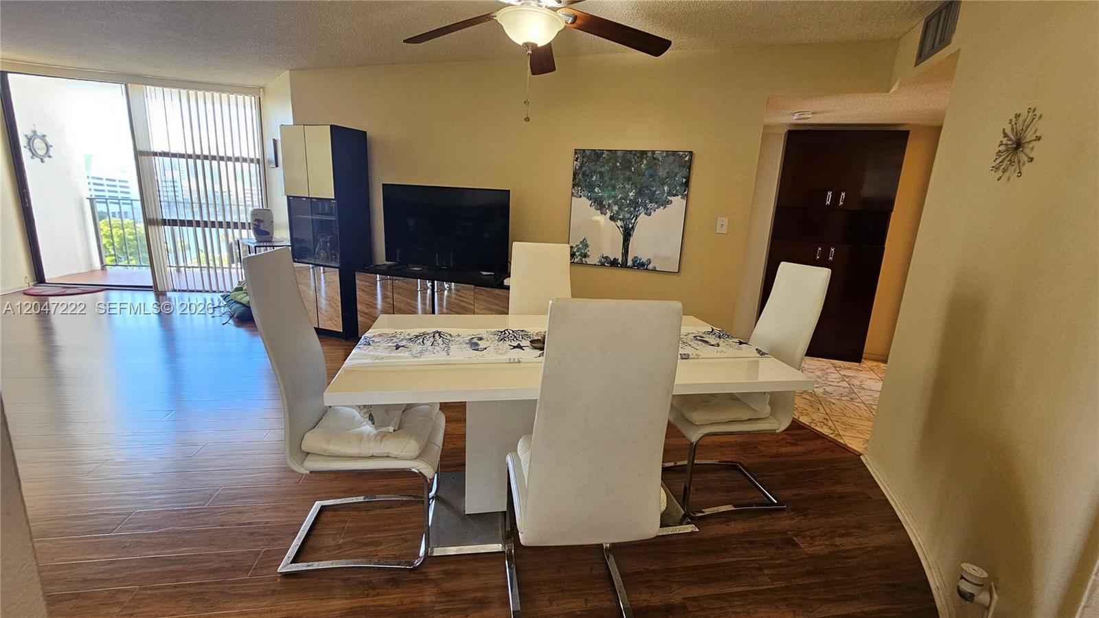 A dining area features a white table with four chairs on wood-look flooring — 800 Parkview Dr # 912, Hallandale Beach FL 33009, HALLANDALE BEACH, FL