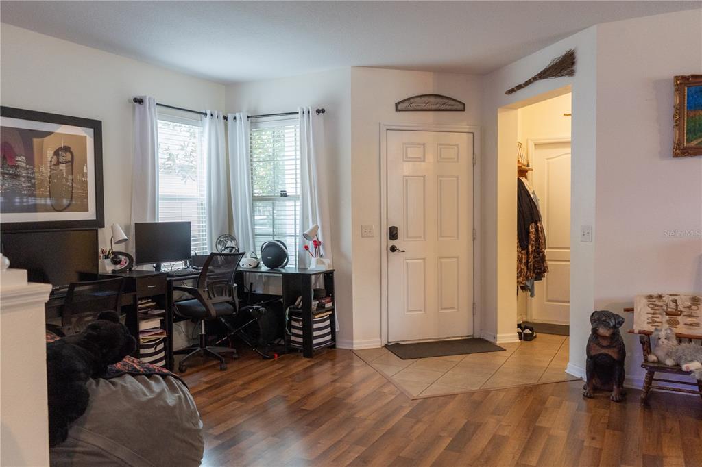A home office area features wood flooring, a desk, and an entryway with a front door — 15647 GREYROCK DRIVE, SPRING HILL, FL