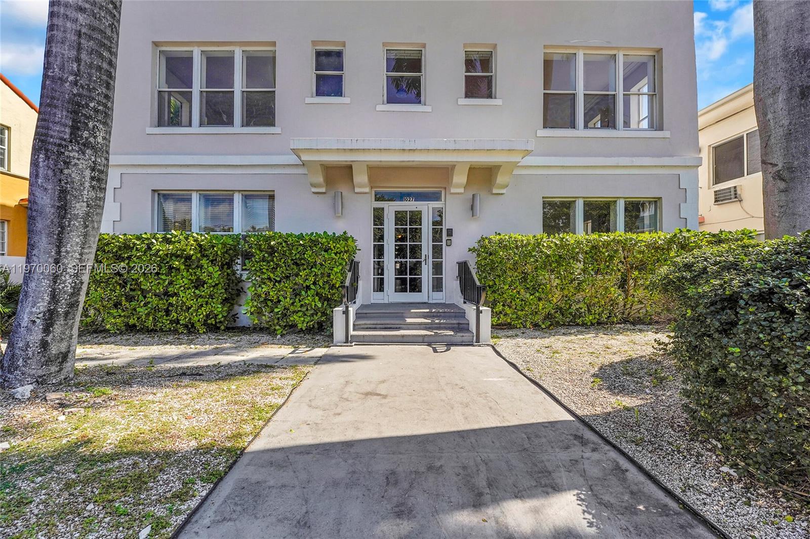 A concrete walkway leads to the front entrance of a multi-story apartment building — 1027 Pennsylvania Ave # 103, Miami Beach FL 33139, MIAMI BEACH, FL