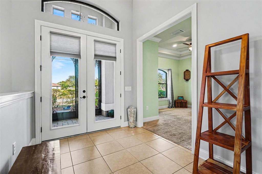 An entryway features tile flooring, double glass doors, and an arched transom window — 2127 SE 17TH PLACE, CAPE CORAL, FL