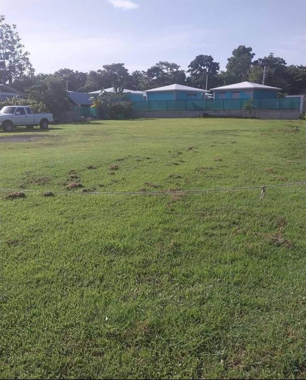A large, grassy vacant lot features a white pickup truck parked on the left side — 429 KM 0.3 POGIO DOLETA STREET UNIT 1, RINCON, PR