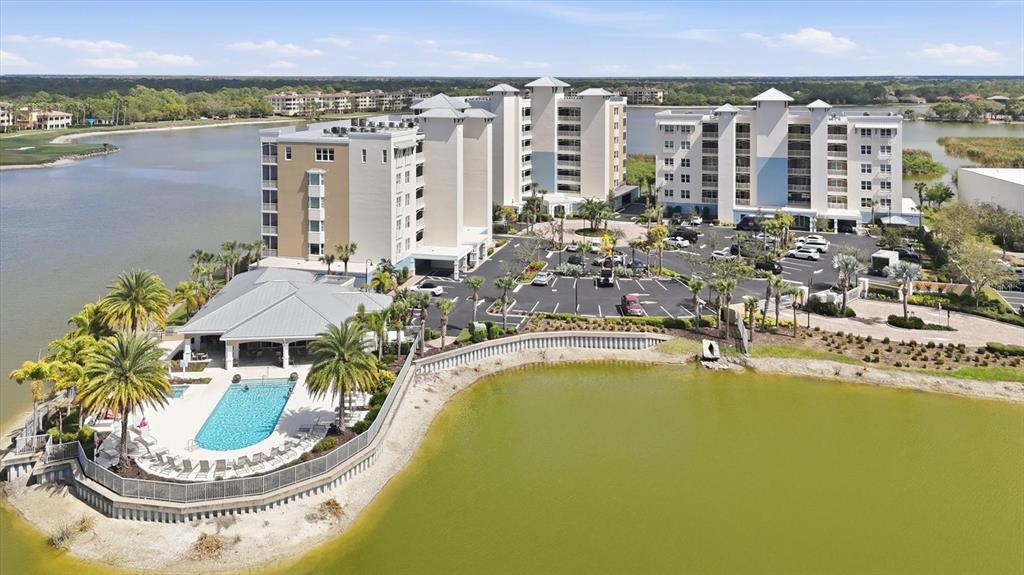 An aerial view shows a multi-story hotel complex with a pool and parking lot — 10510 BOARDWALK LOOP UNIT 602, LAKEWOOD RANCH, FL