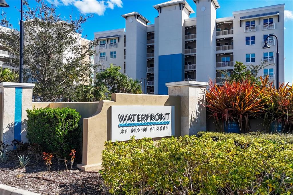 A sign for Waterfront at Main Street stands in front of a large apartment building — 10510 BOARDWALK LOOP UNIT 602, LAKEWOOD RANCH, FL