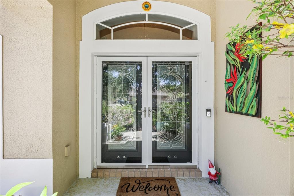 A front entryway features double glass doors with decorative inserts and a welcome mat — 1901 HEARTLAND CIRCLE, VALRICO, FL